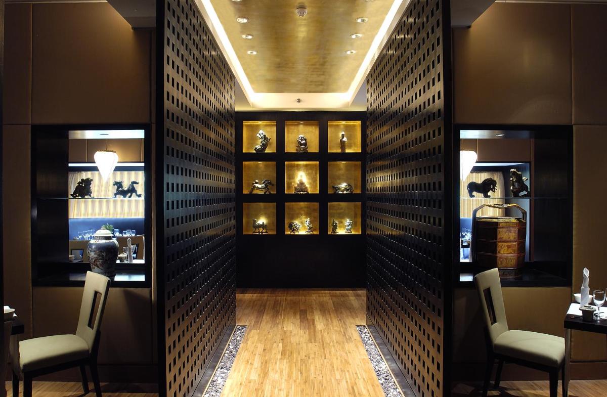 a room with a wall with shelves of vases at The Claridges New Delhi in New Delhi a room with a wall with shelves of vases at The Claridges New Delhi in New Delhi