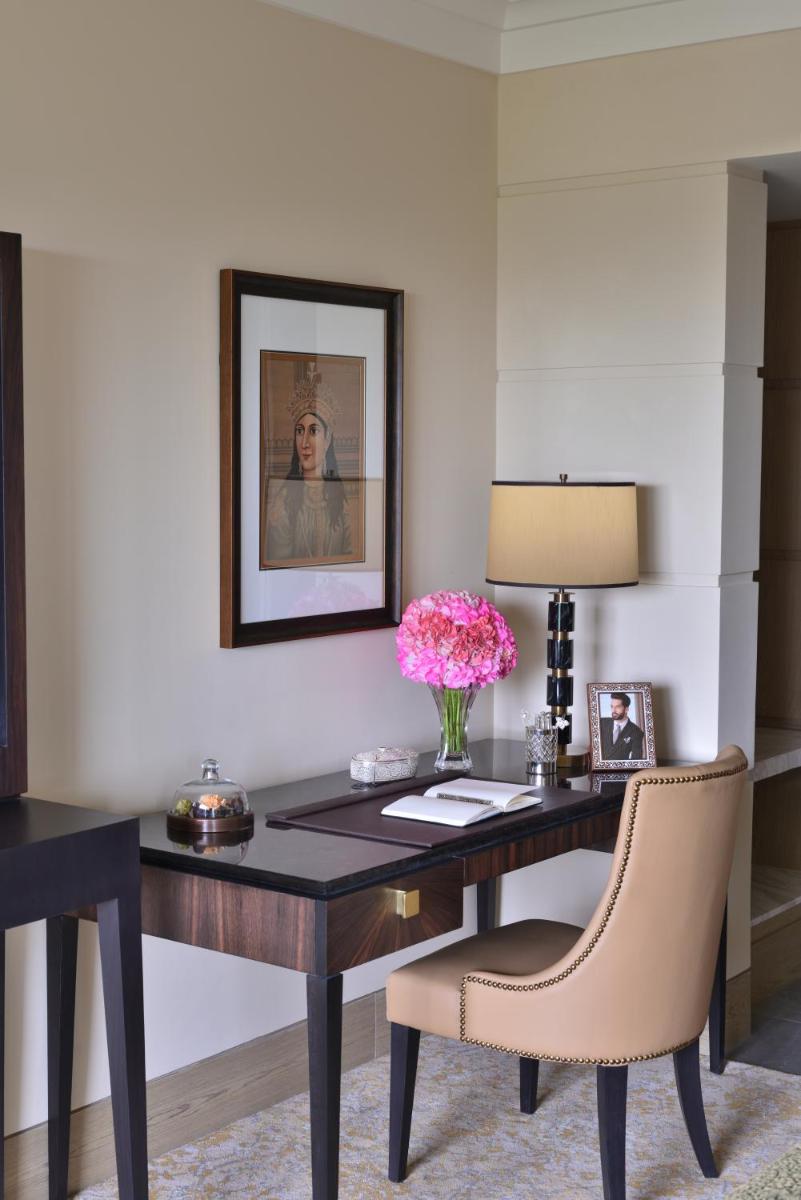 a desk with a vase of flowers and a chair at Taj Mahal, New Delhi in New Delhi