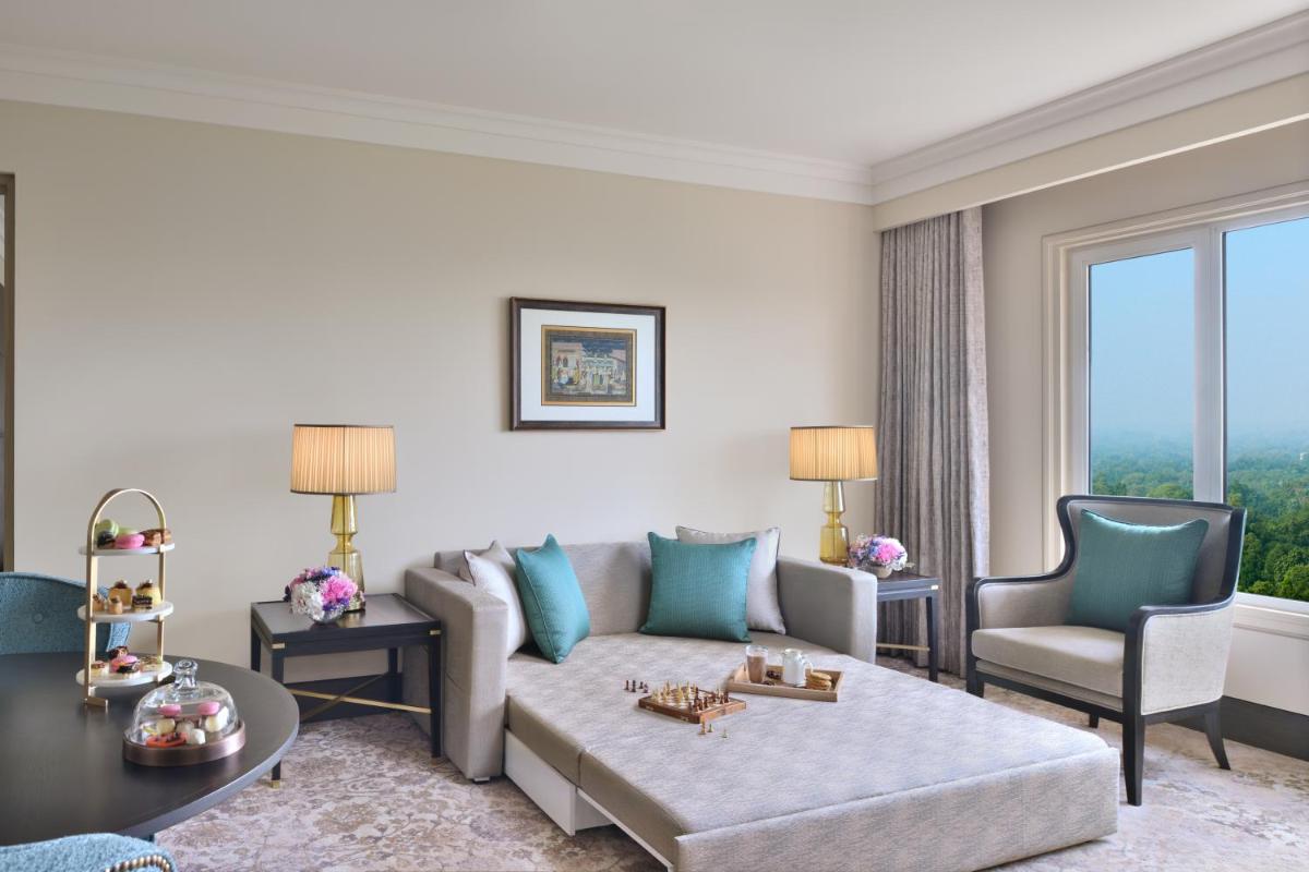 a living room with a couch and a table and chairs at Taj Mahal, New Delhi in New Delhi