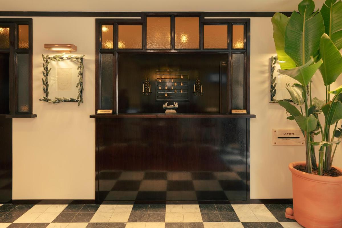 La salle de bains est pourvue d'une porte noire et d'une plante en pot. dans l'établissement Hotel la Ponche, à Saint-Tropez