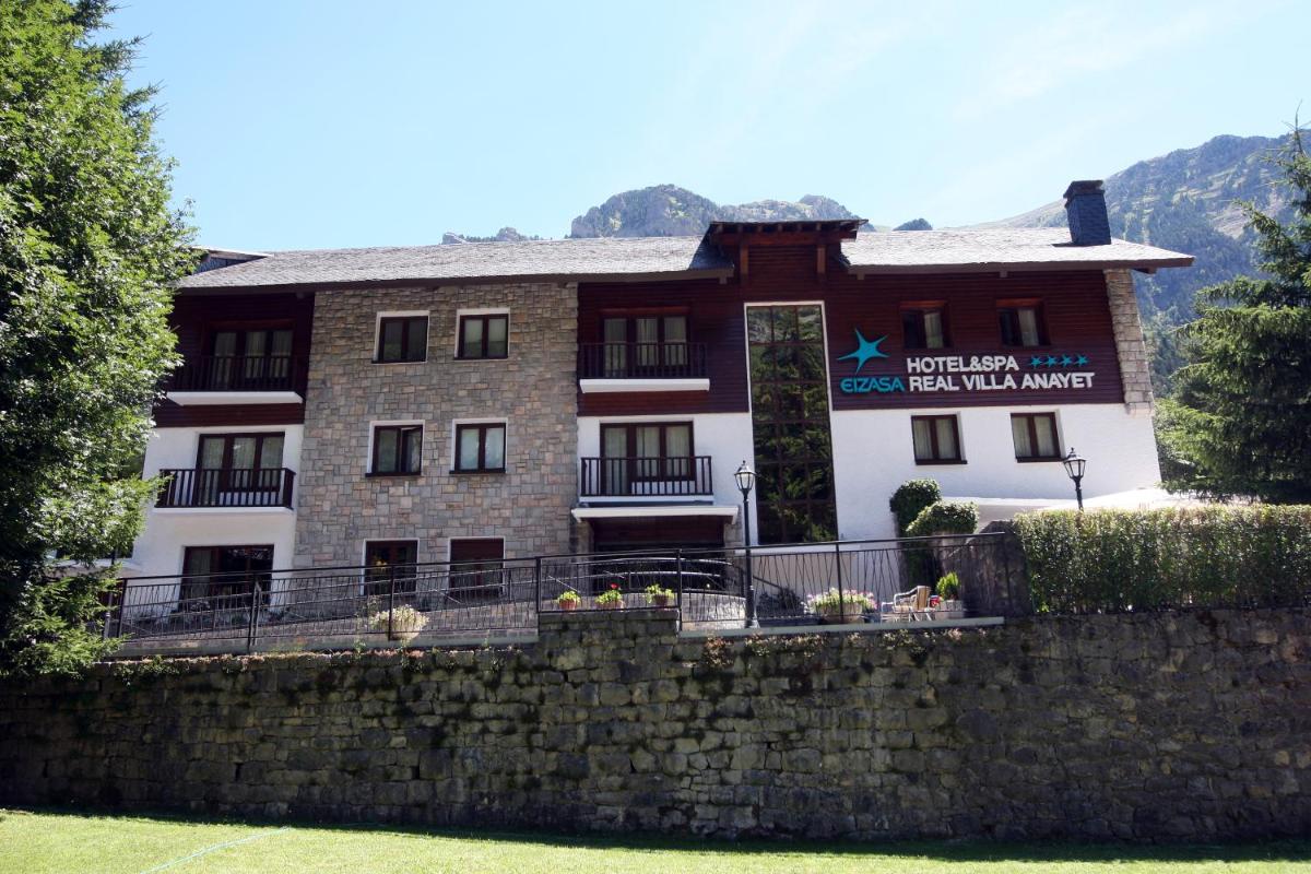 un edificio en la parte superior de una pared de piedra en Hotel & Spa Real Villa Anayet, en Canfranc-Estación