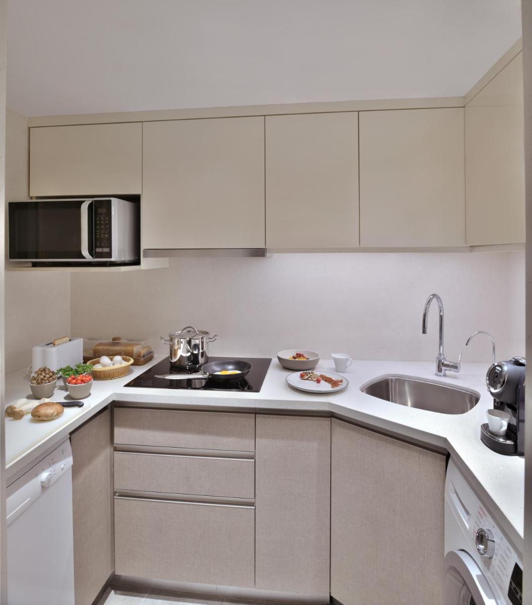 a kitchen with white cabinets and a sink at Taj Mahal, New Delhi in New Delhi