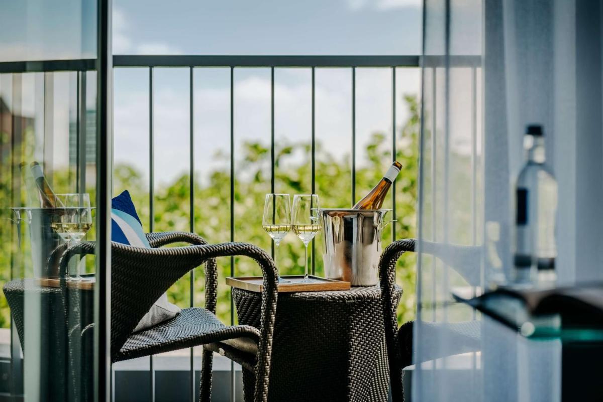 ein Tisch mit Weinflaschen und Gläsern auf einem Balkon in der Unterkunft Hotel Kö59 Düsseldorf - Member of Hommage Luxury Hotels Collection in Düsseldorf