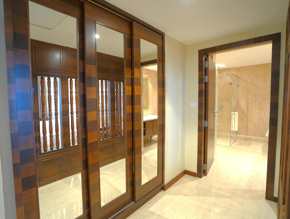 a bathroom with wooden doors and a walk in shower at Taj Tirupati in Tirupati