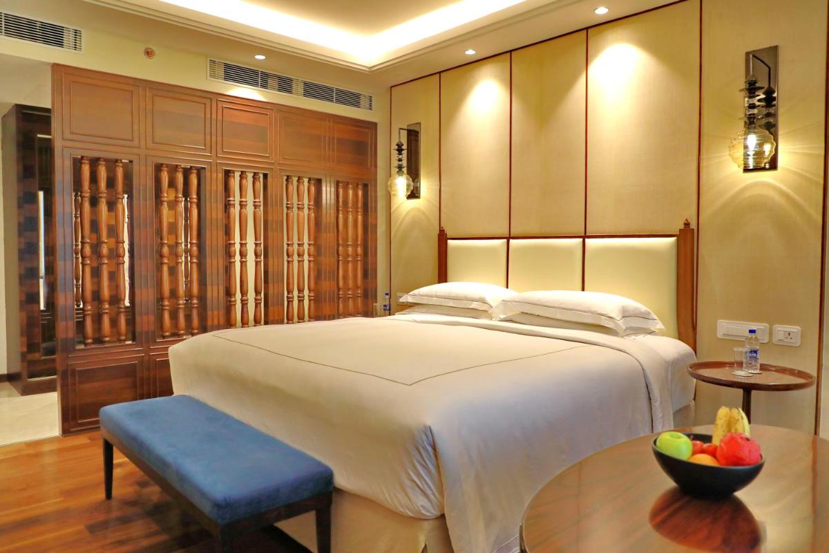 a bedroom with a large bed and a bowl of fruit at Taj Tirupati in Tirupati
