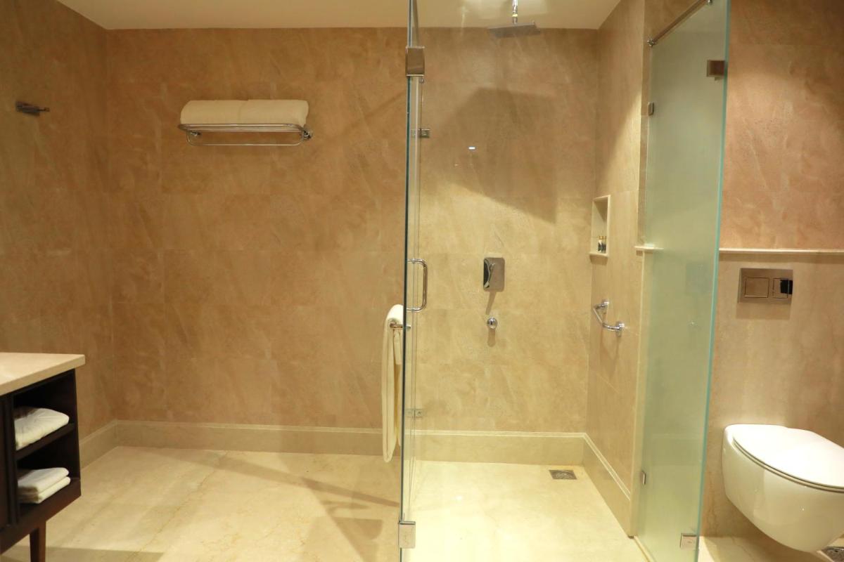 a bathroom with a glass shower with a toilet at Taj Tirupati in Tirupati