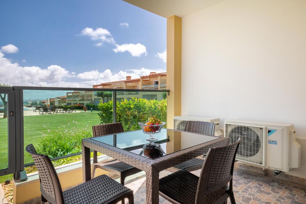 um pátio com uma mesa e cadeiras e uma grande janela em Boavista Golf & Spa - Bela Colina Holidays em Lagos