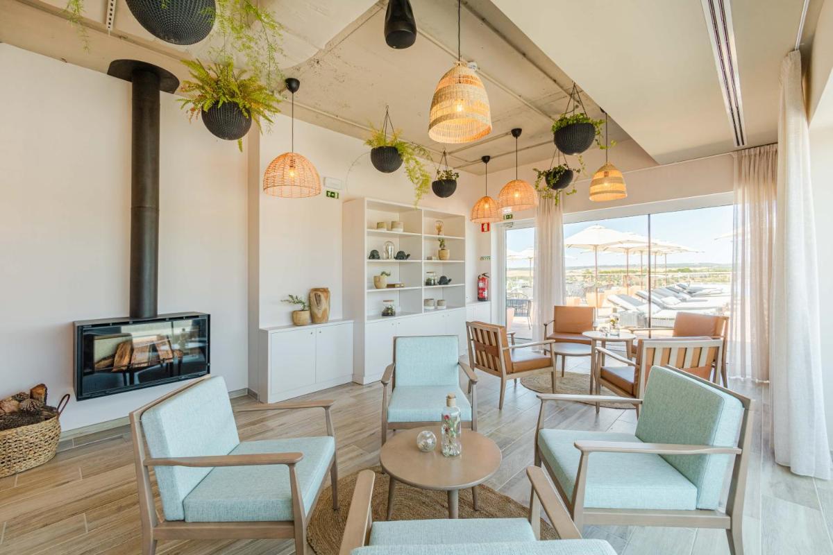 uma sala de estar com cadeiras, uma televisão e uma mesa em Sleep & Nature Hotel em Lavre