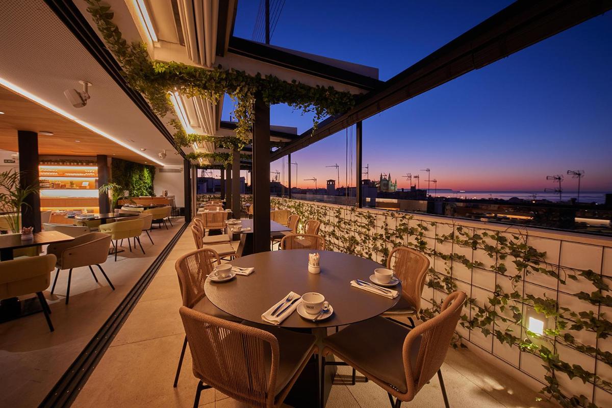Un restaurante con una mesa y sillas en un balcón. en Nakar Hotel, en Palma de Mallorca