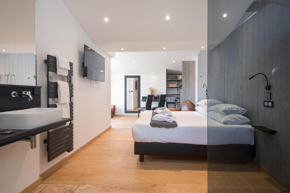 Un ou plusieurs lits dans un hébergement de l'établissement Elégance Suites Hôtel