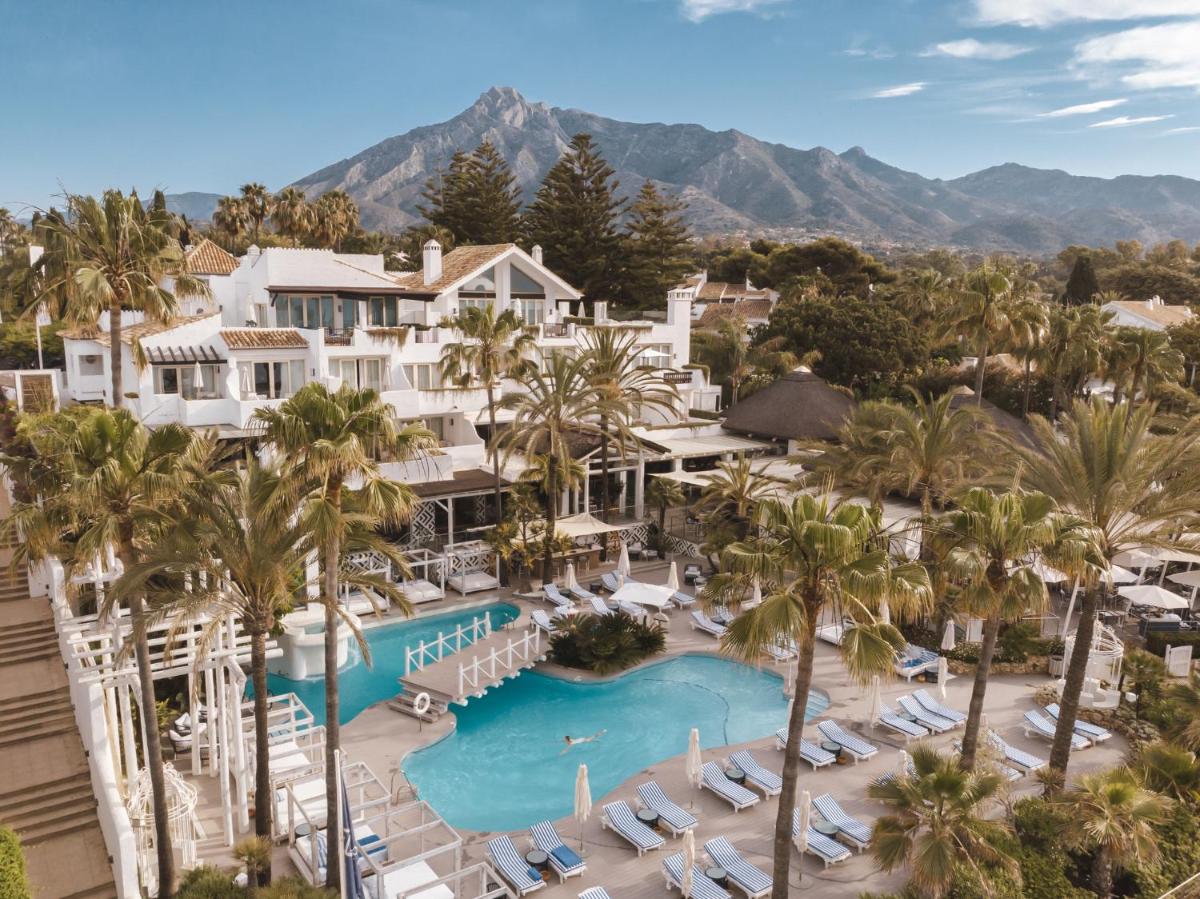 Una vista aérea de un resort con piscina y palmeras. en Puente Romano Marbella, en Marbella