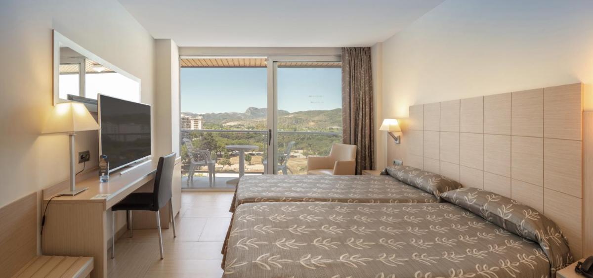 Una habitación de hotel con una cama y una ventana grande. en Hotel RH Bayren Parc, en Gandía