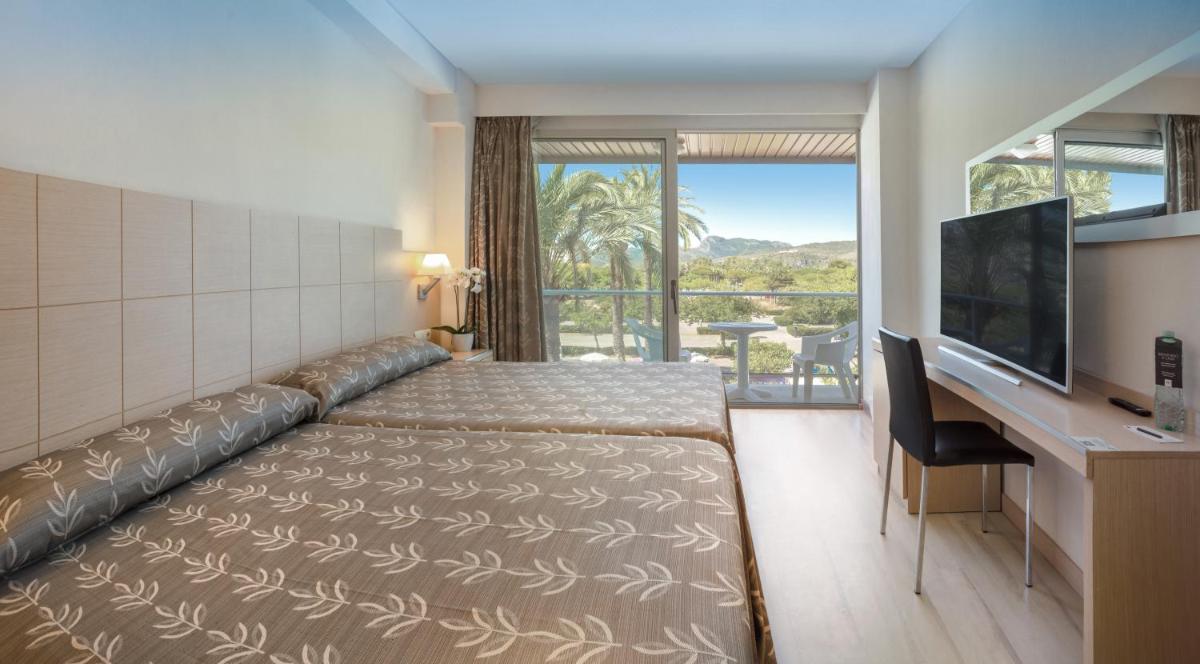 Una habitación de hotel con una cama grande y un televisor. en Hotel RH Bayren Parc, en Gandía