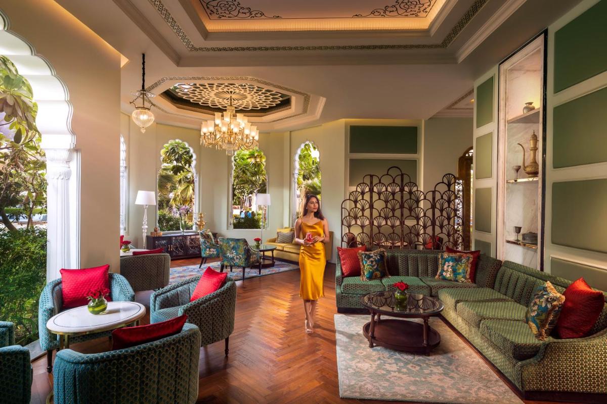 a woman walks through the lobby of a hotel at The Leela Palace Jaipur in Jaipur