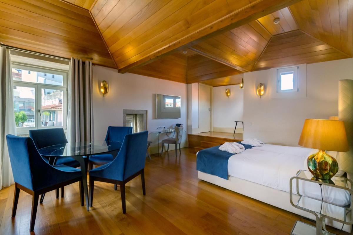 um quarto com uma cama, uma mesa e cadeiras em Oca Flores Hotel Boutique no Porto