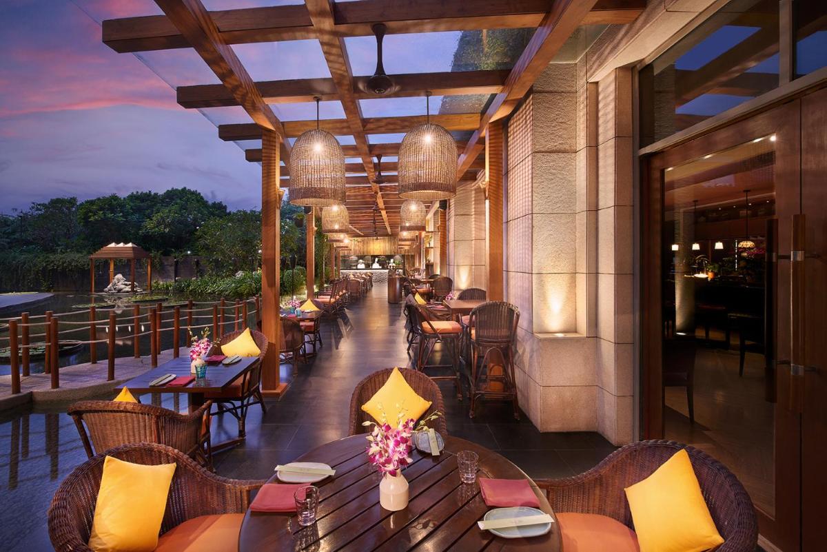 a restaurant with tables and chairs on a patio at Park Hyatt Chennai in Chennai