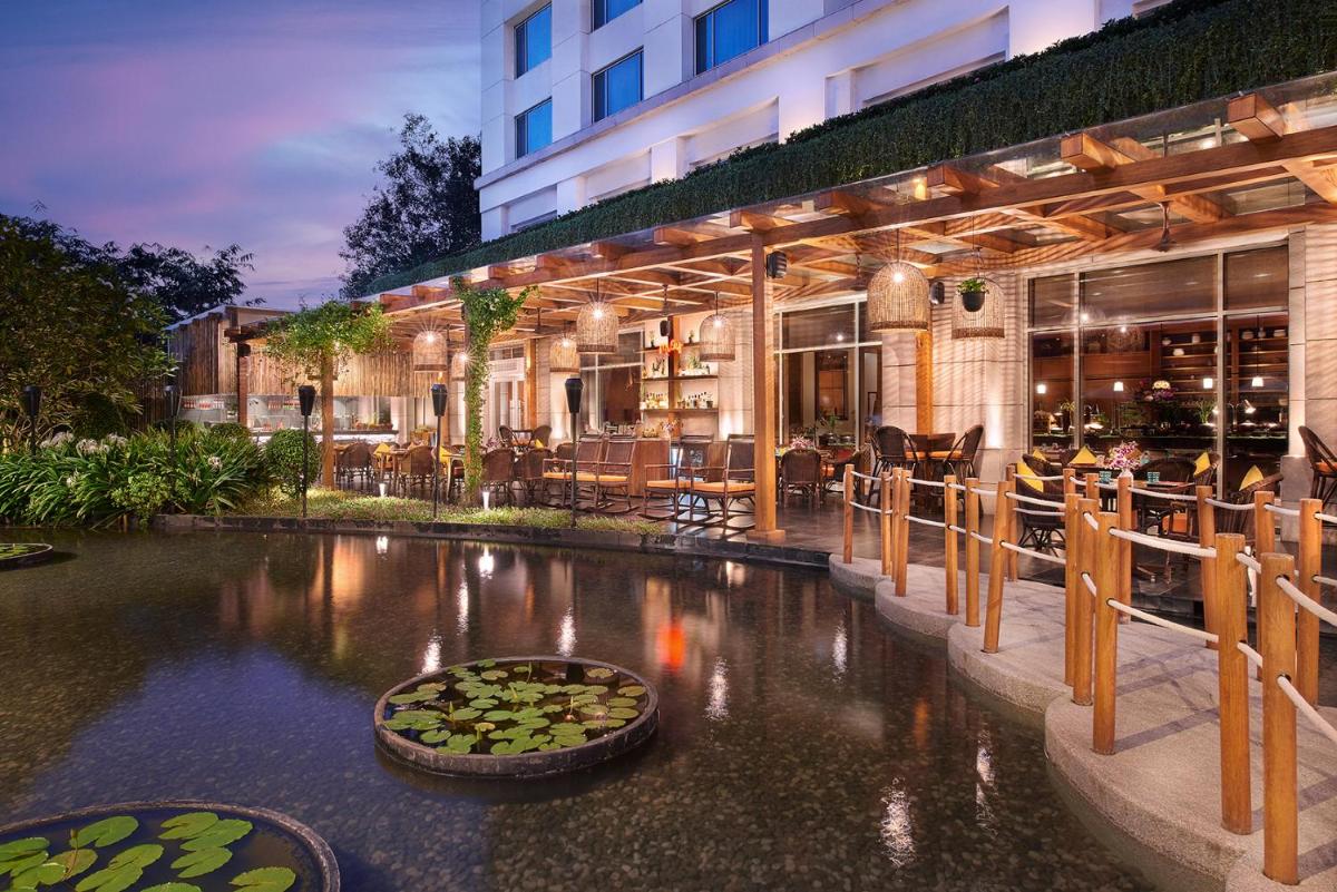 a hotel with a pond with lily pads in it at Park Hyatt Chennai in Chennai