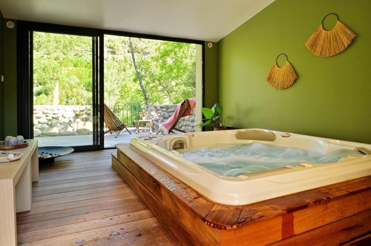 une grande baignoire dans une pièce aux murs verts dans l'établissement Hotel E Caselle - Demeures & Châteaux, à Venaco