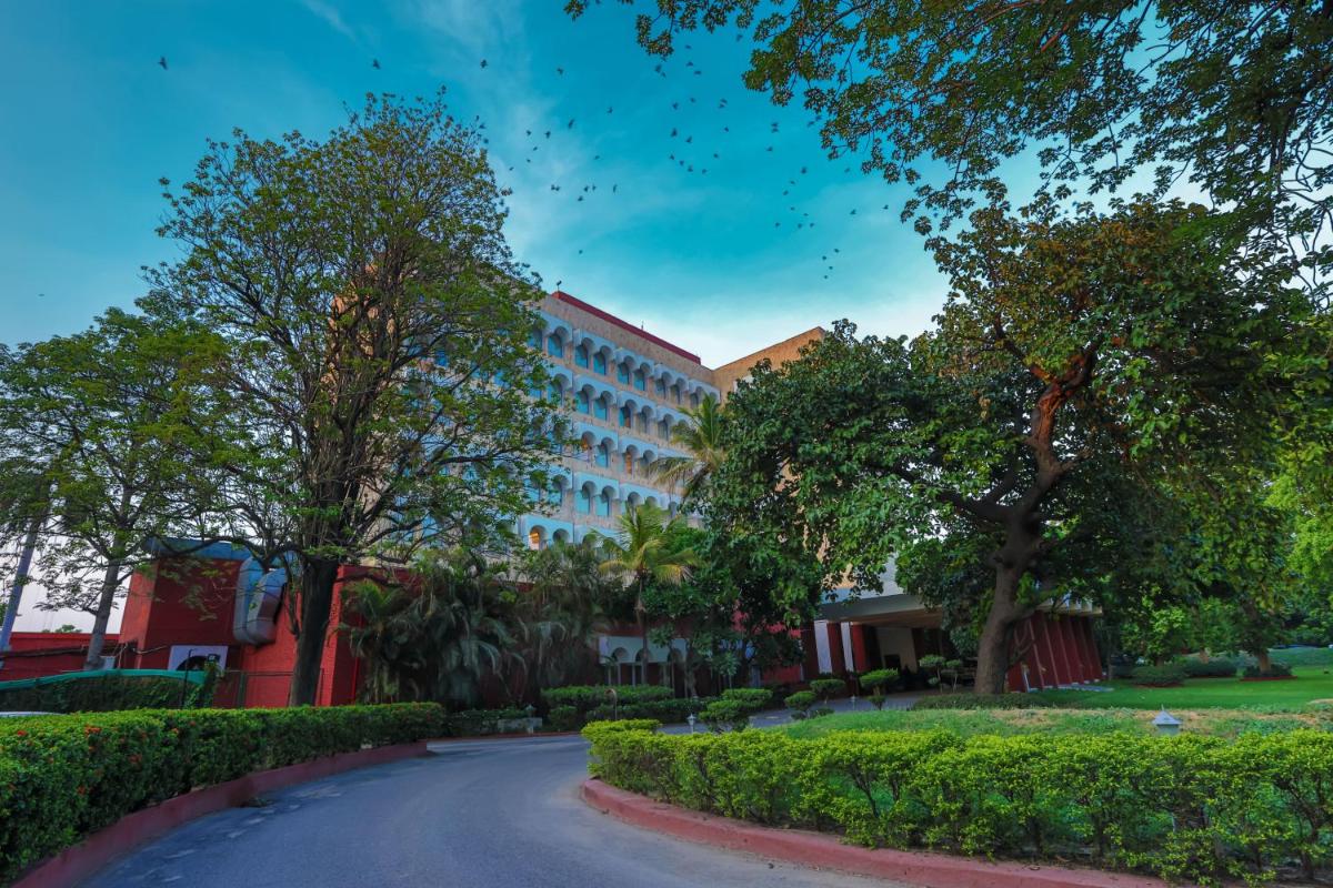 a road in front of a building with trees at Taj Ganges Varanasi in Varanasi