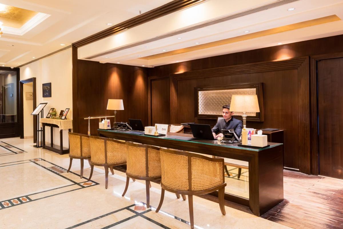 a man sitting at a desk in a hotel lobby at Taj Ganges Varanasi in Varanasi
