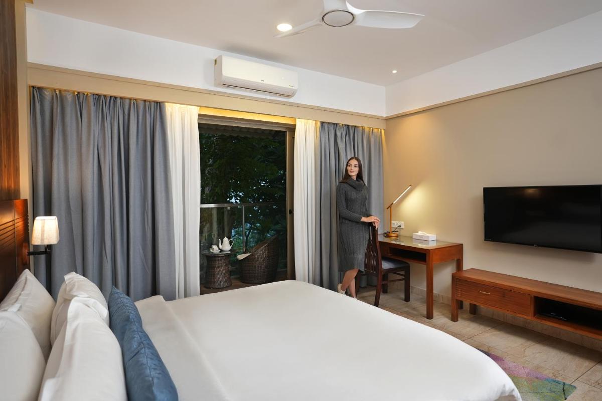 a woman is standing in a hotel room at Elephant Passage in Munnar