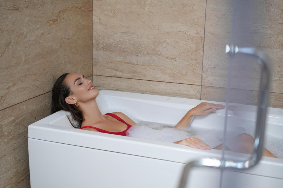 a woman is sitting in a bath tub at Elephant Passage in Munnar