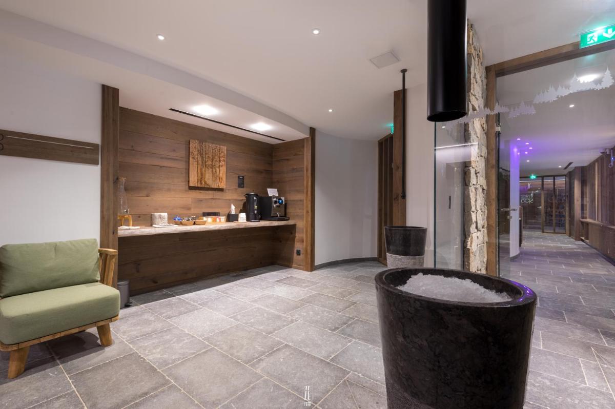 un hall d'entrée avec une chaise et un comptoir dans l'établissement Chalet Hôtel & Spa Le Collet, à Xonrupt-Longemer 117 autres photos