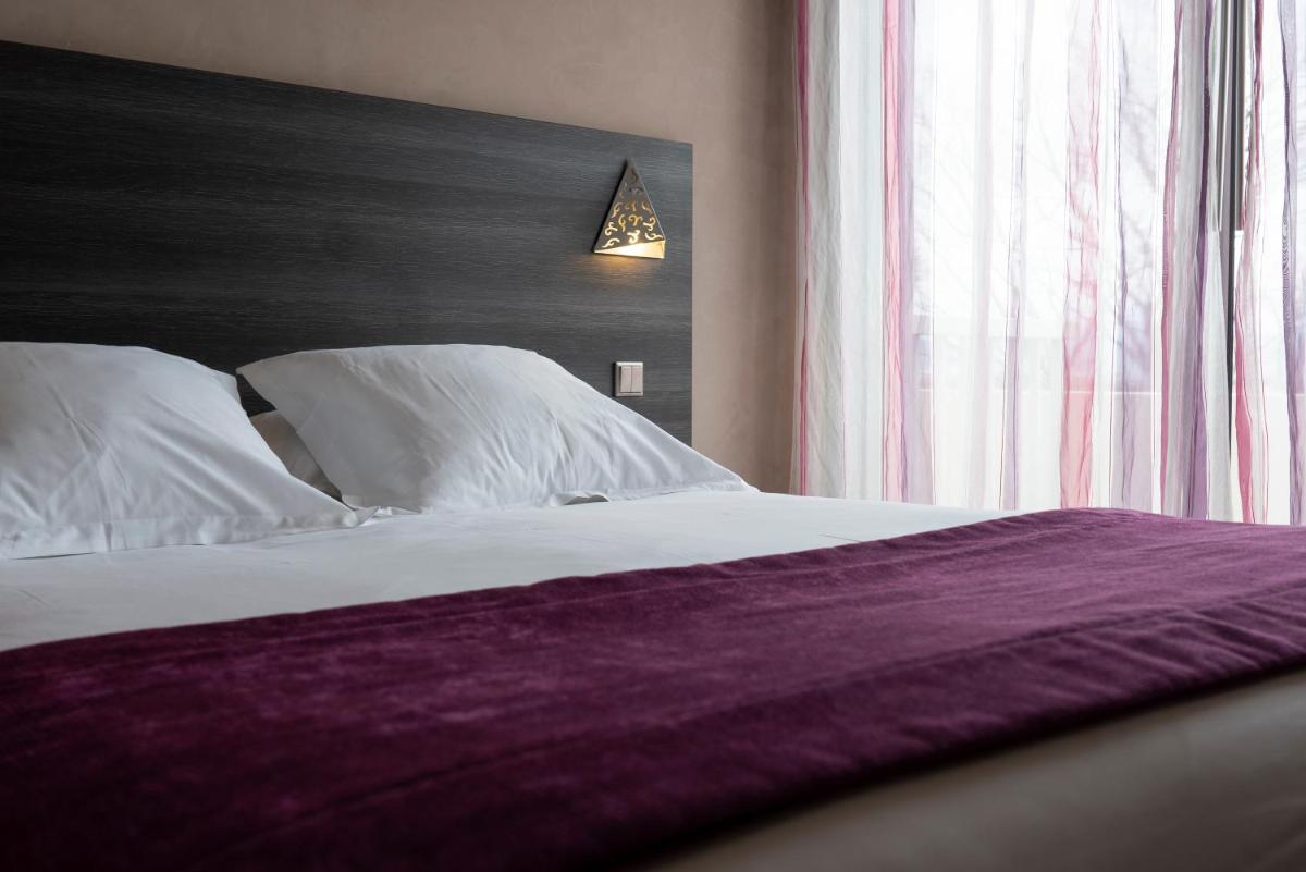 Un ou plusieurs lits dans un hébergement de l'établissement Logis Hotel Restaurant SPA Les Oliviers