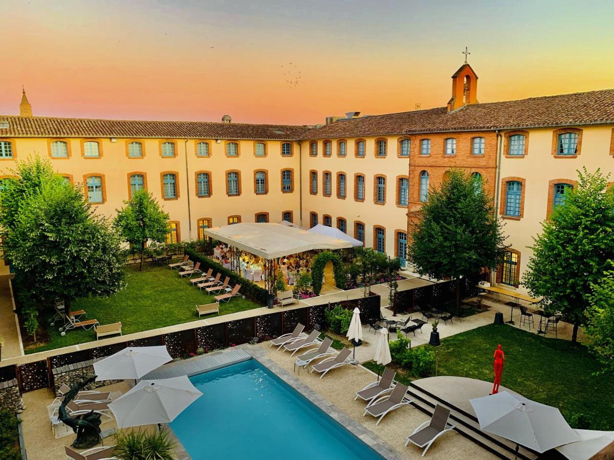 un hôtel avec une piscine et un bâtiment dans l'établissement Abbaye des Capucins Spa & Resort, à Montauban