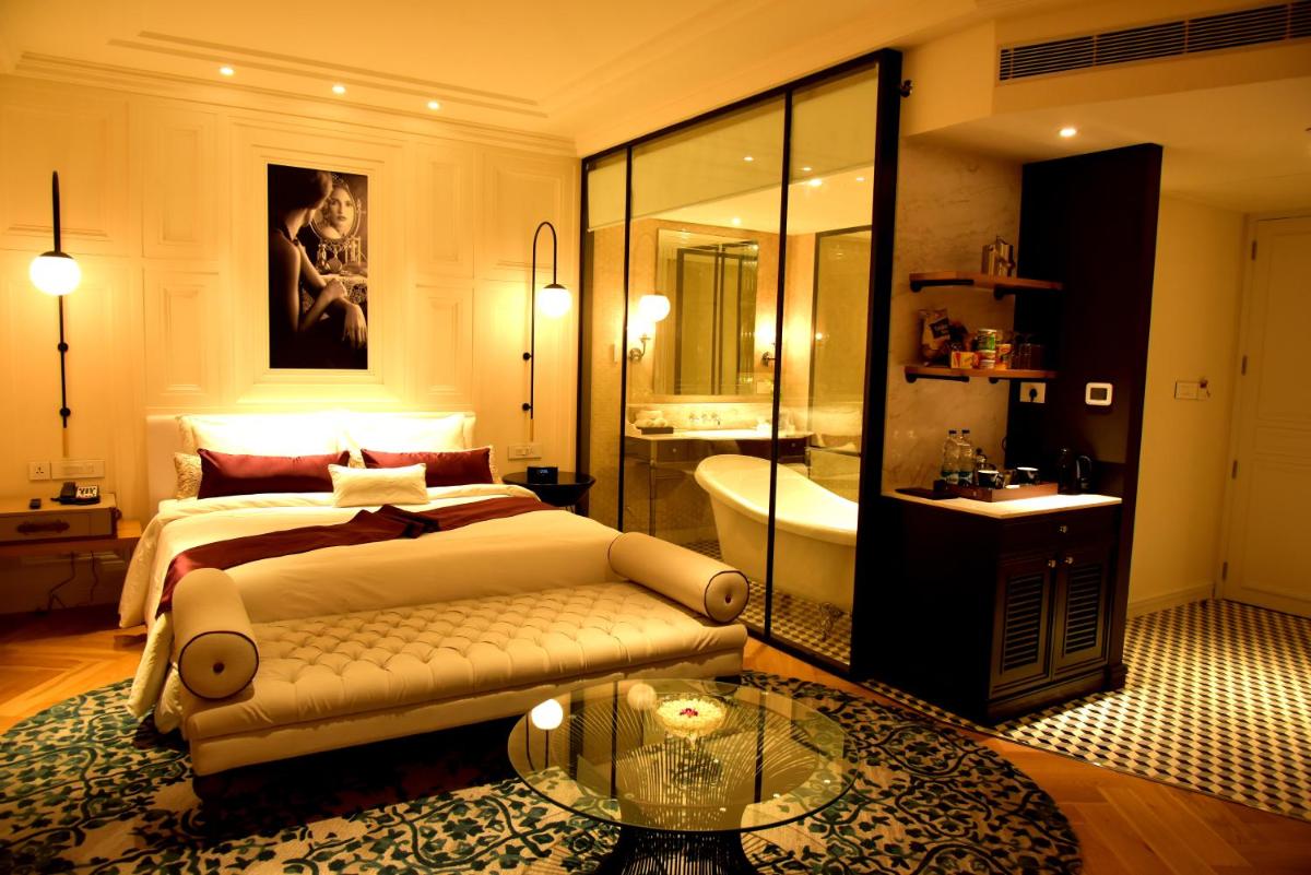 a bedroom with a bed and a bathroom with a tub at Radisson Hotel Shimla in Shimla
