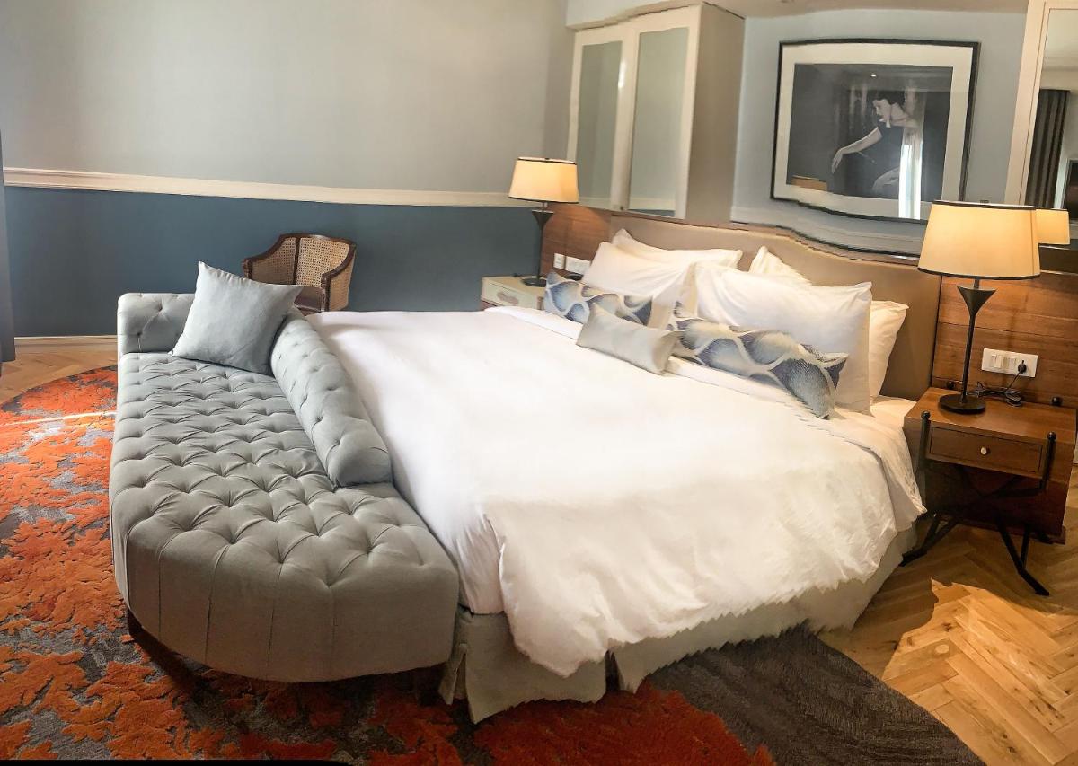 a bedroom with a large white bed and a couch at Radisson Hotel Shimla in Shimla