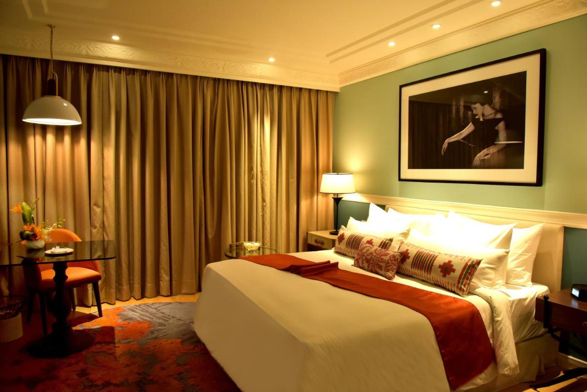 a hotel room with a large bed and a table at Radisson Hotel Shimla in Shimla