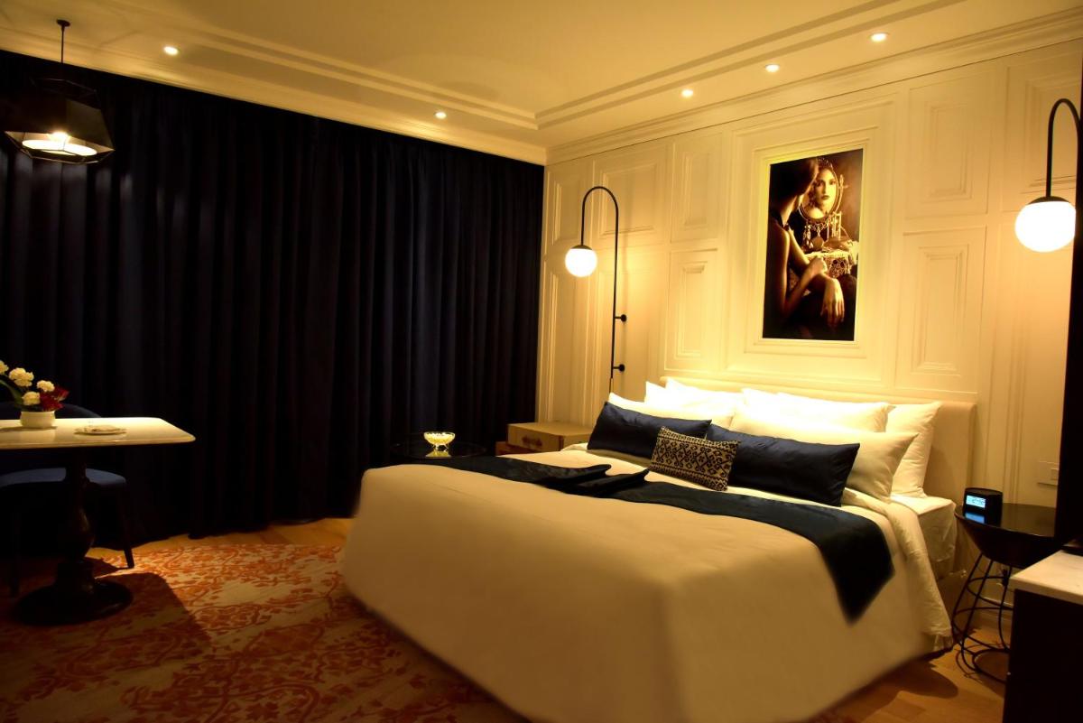 a bedroom with a large white bed and a table at Radisson Hotel Shimla in Shimla