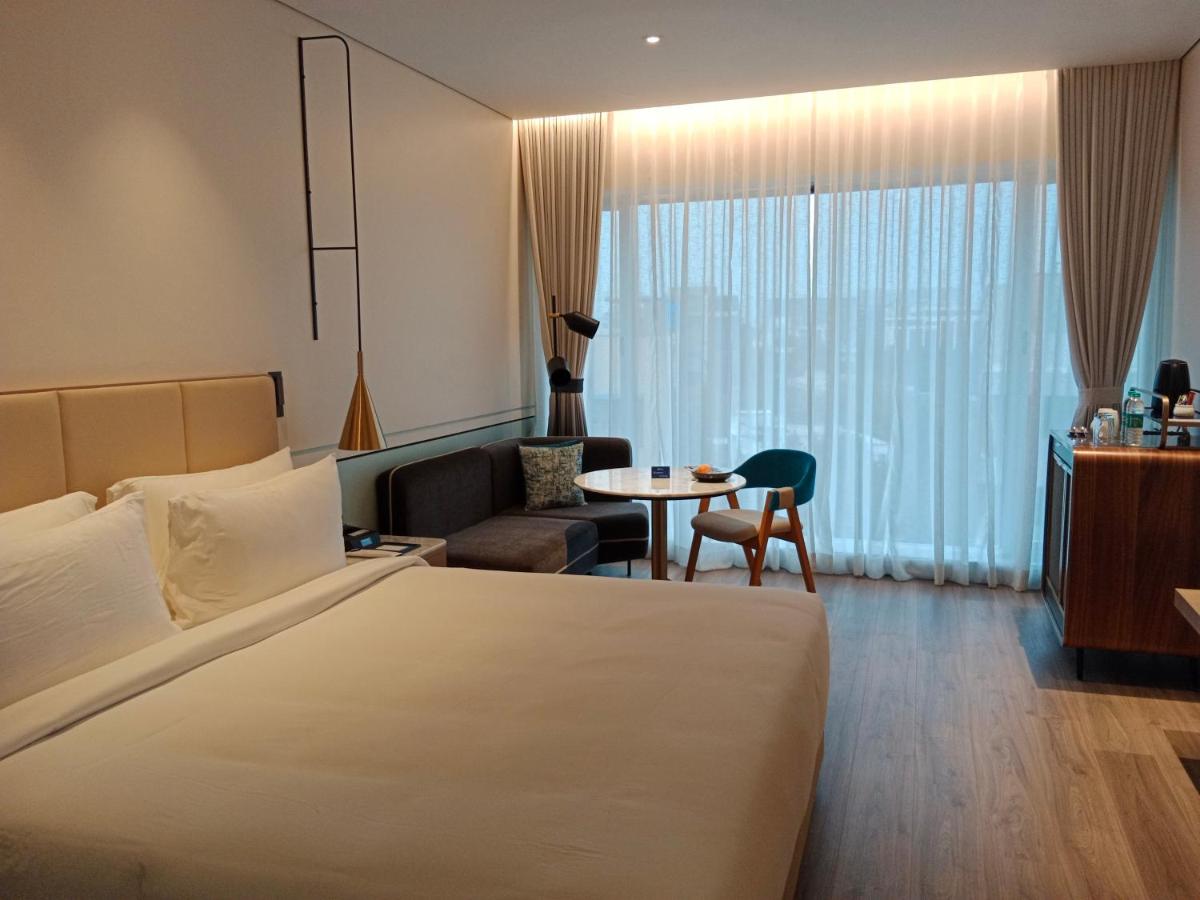 a hotel room with a large bed and a table at Radisson Blu Mumbai International Airport in Mumbai a hotel room with a large bed and a table at Radisson Blu Mumbai International Airport in Mumbai