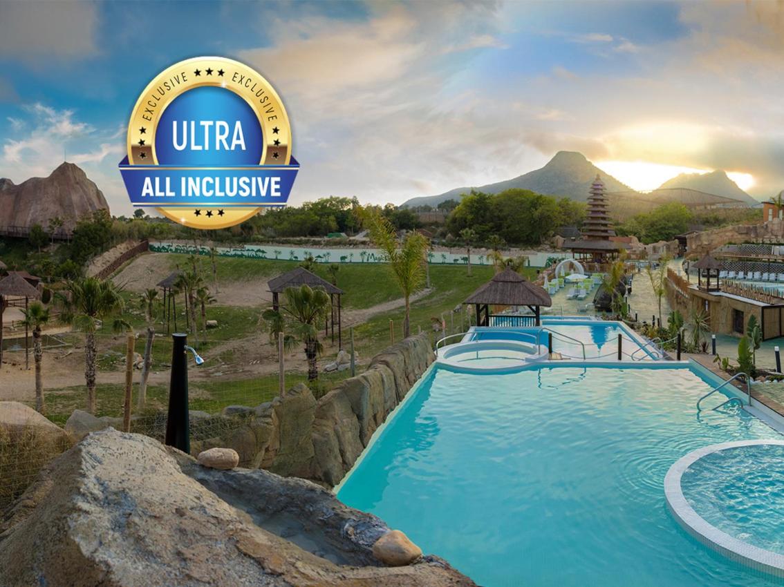 Una piscina en un resort con un cartel que dice ultra todo incluido. en Magic Natura Resort, en Benidorm