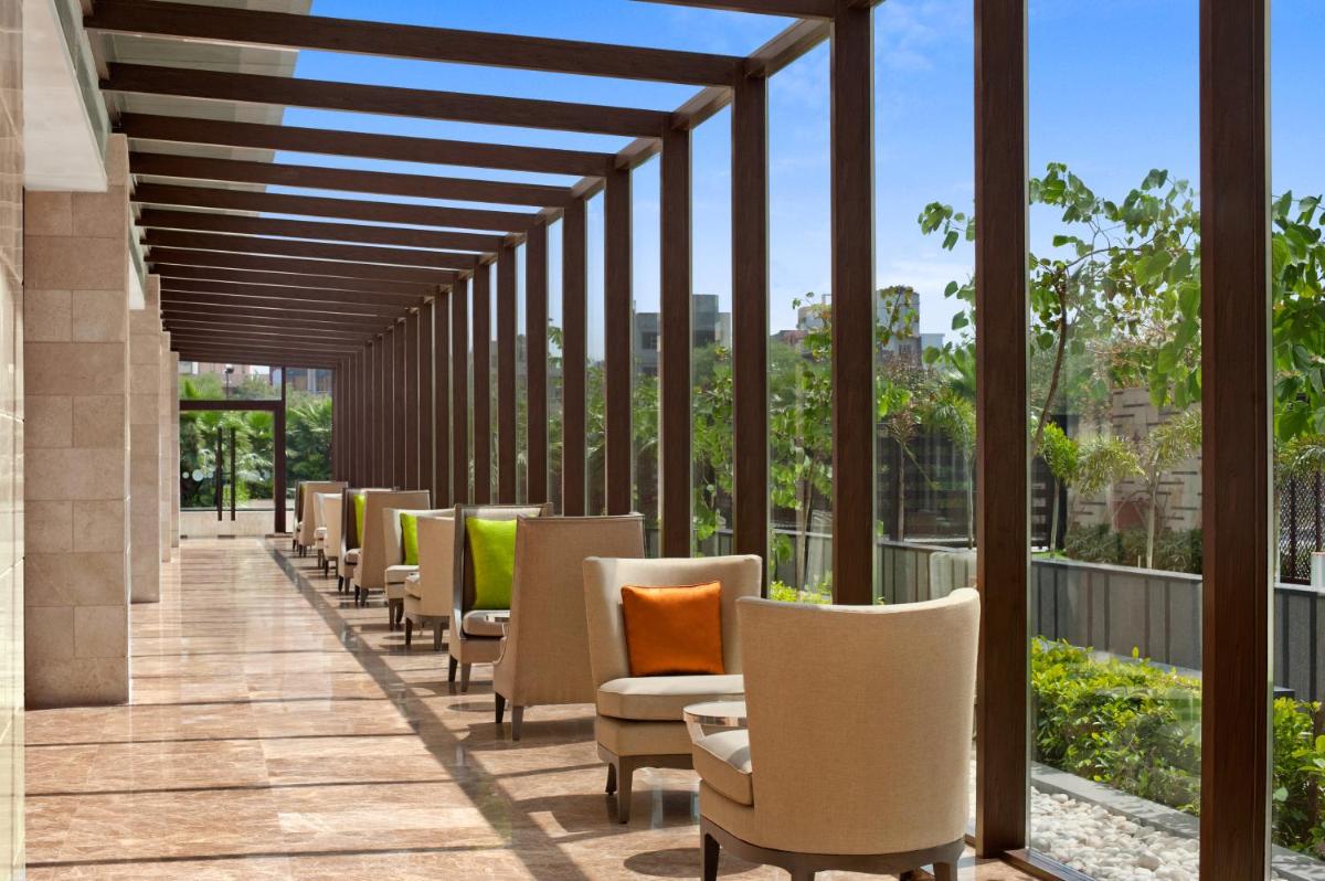 a row of chairs and tables on a balcony at The Leela Ambience Convention Hotel Delhi in New Delhi