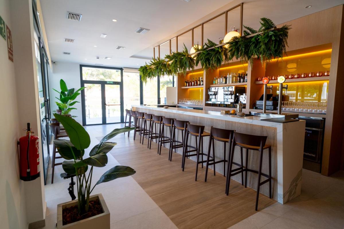un bar con una fila de taburetes en Alannia Salou, en Salou
