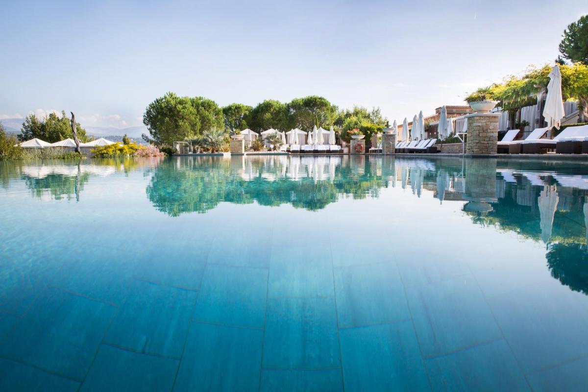 un grand bassin d'eau avec des bâtiments en arrière-plan dans l'établissement Terre Blanche Hotel Spa Golf Resort, à Tourrettes