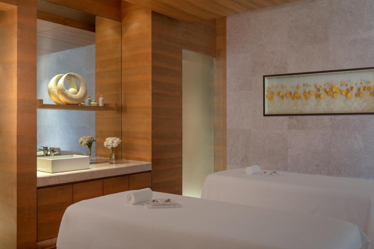 a bathroom with two beds and a mirror and a sink at Hyatt Regency Chandigarh in Chandīgarh