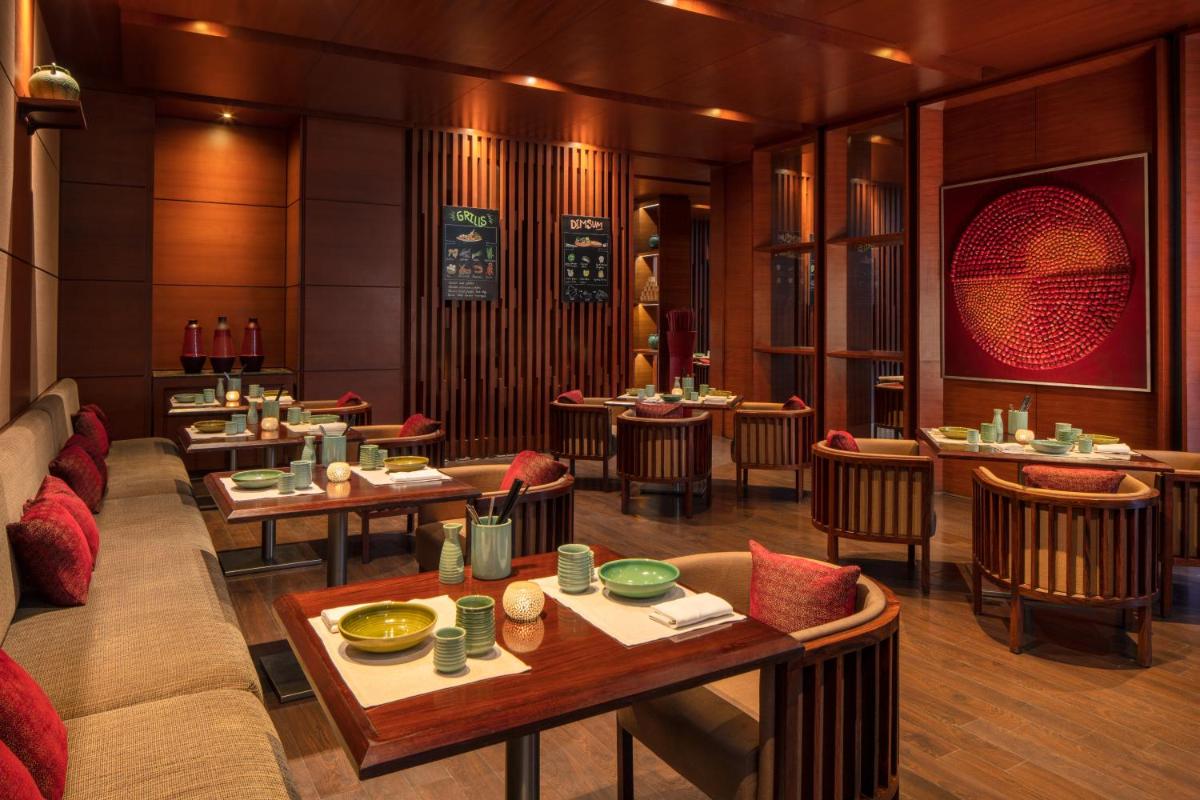 a restaurant with tables and chairs in a room at Hyatt Regency Chandigarh in Chandīgarh