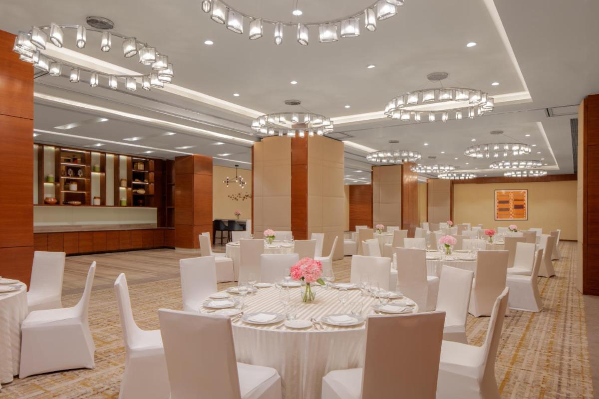 a banquet hall with white tables and chairs and chandeliers at Hyatt Regency Chandigarh in Chandīgarh +80 photos