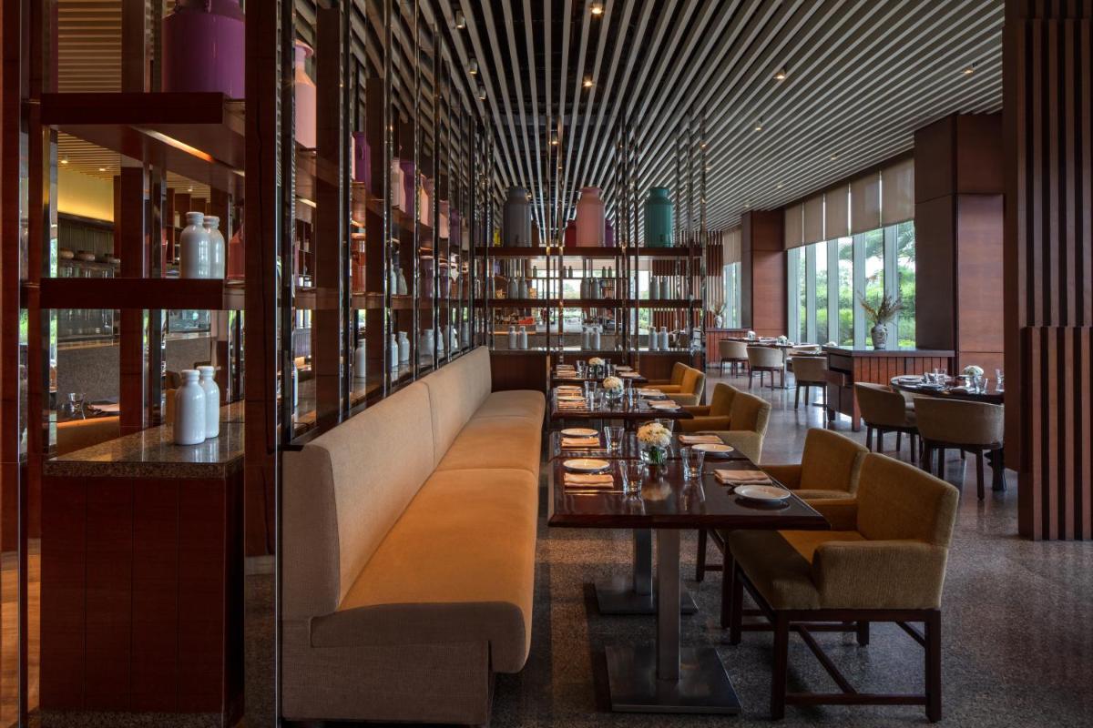 a dining room with tables and chairs in a restaurant at Hyatt Regency Chandigarh in Chandīgarh