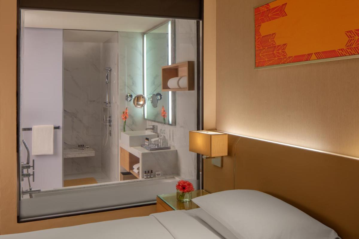 a bedroom with a bed and a shower and a bathroom at Hyatt Regency Chandigarh in Chandīgarh