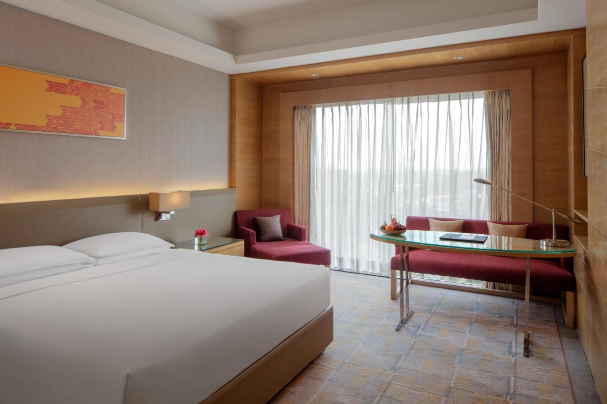 a hotel room with a bed and a table and chairs at Hyatt Regency Chandigarh in Chandīgarh