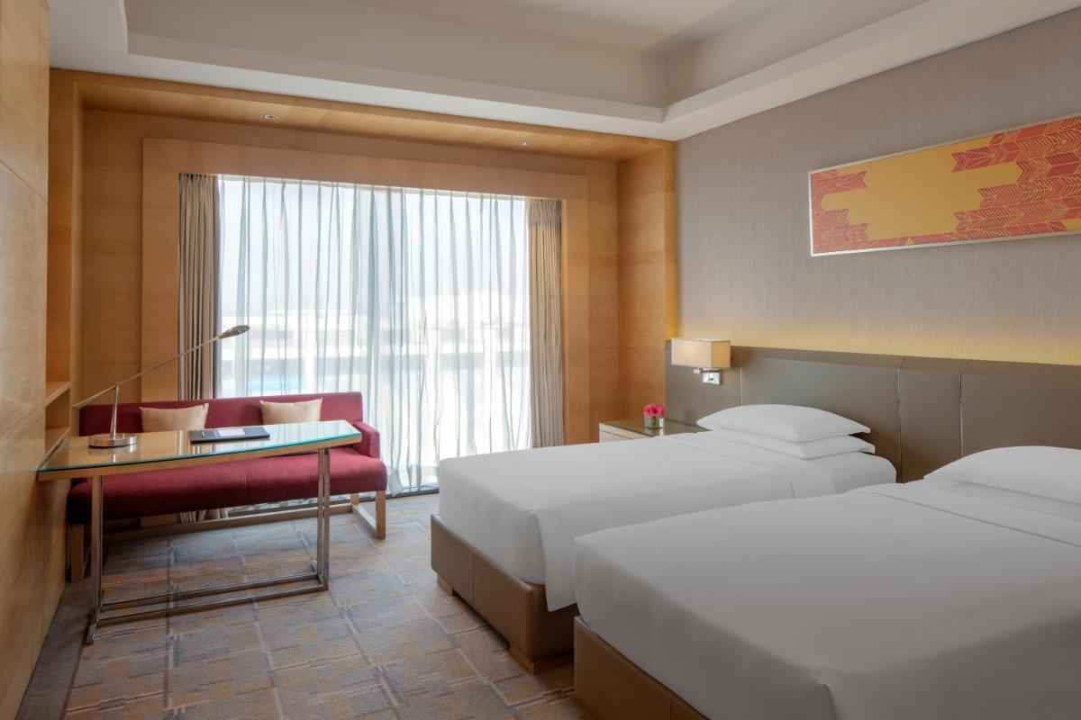 a hotel room with two beds and a desk at Hyatt Regency Chandigarh in Chandīgarh