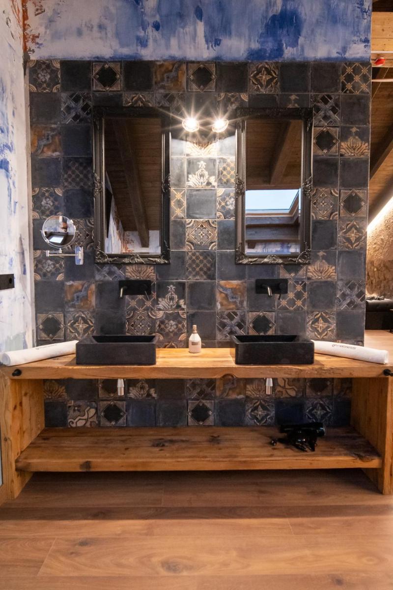 un baño con dos lavabos y dos espejos en HOTEL SOMNIFABRIK, en Valderrobres