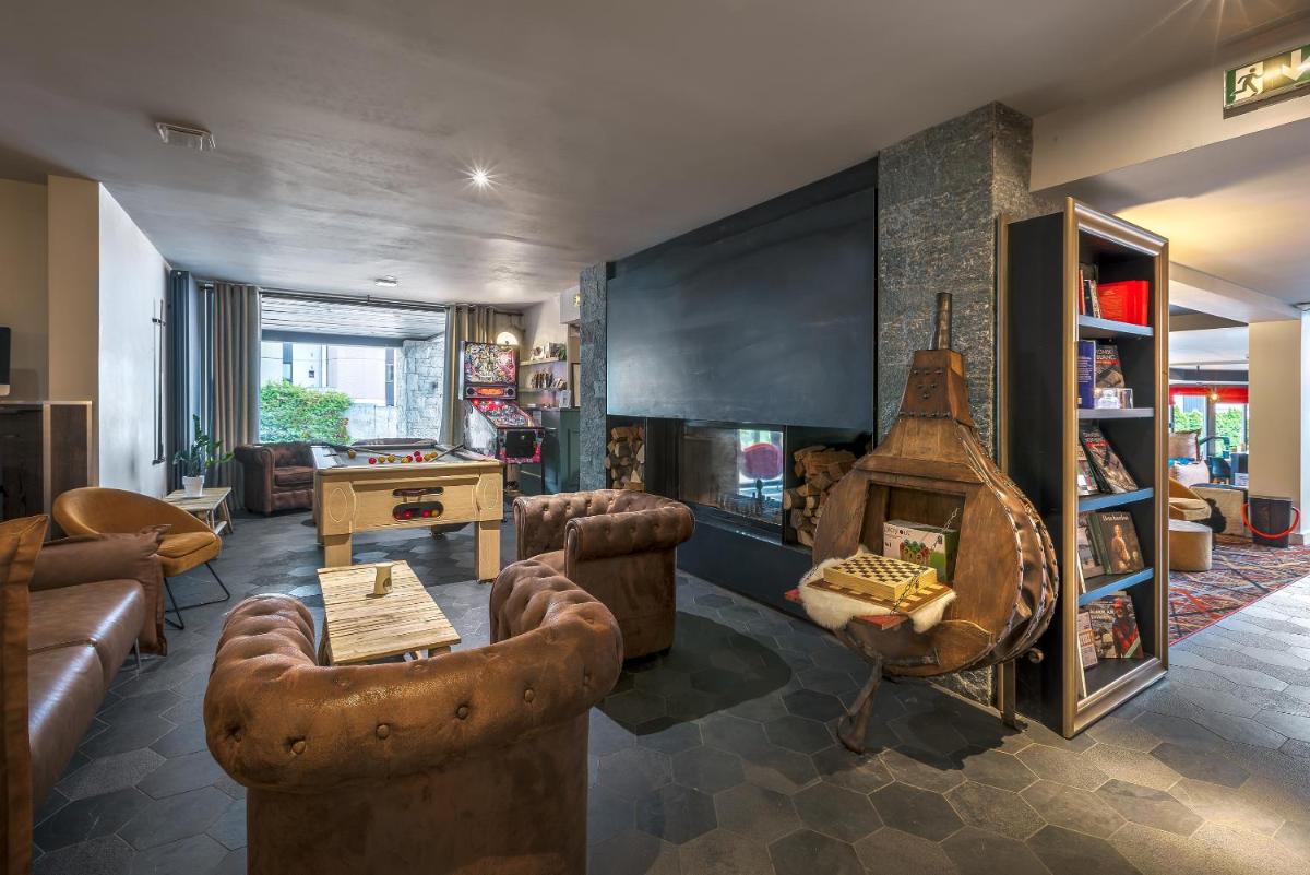 un salon avec un canapé et une cheminée dans l'établissement Chalet Hôtel Le Prieuré & Spa, à Chamonix-Mont-Blanc