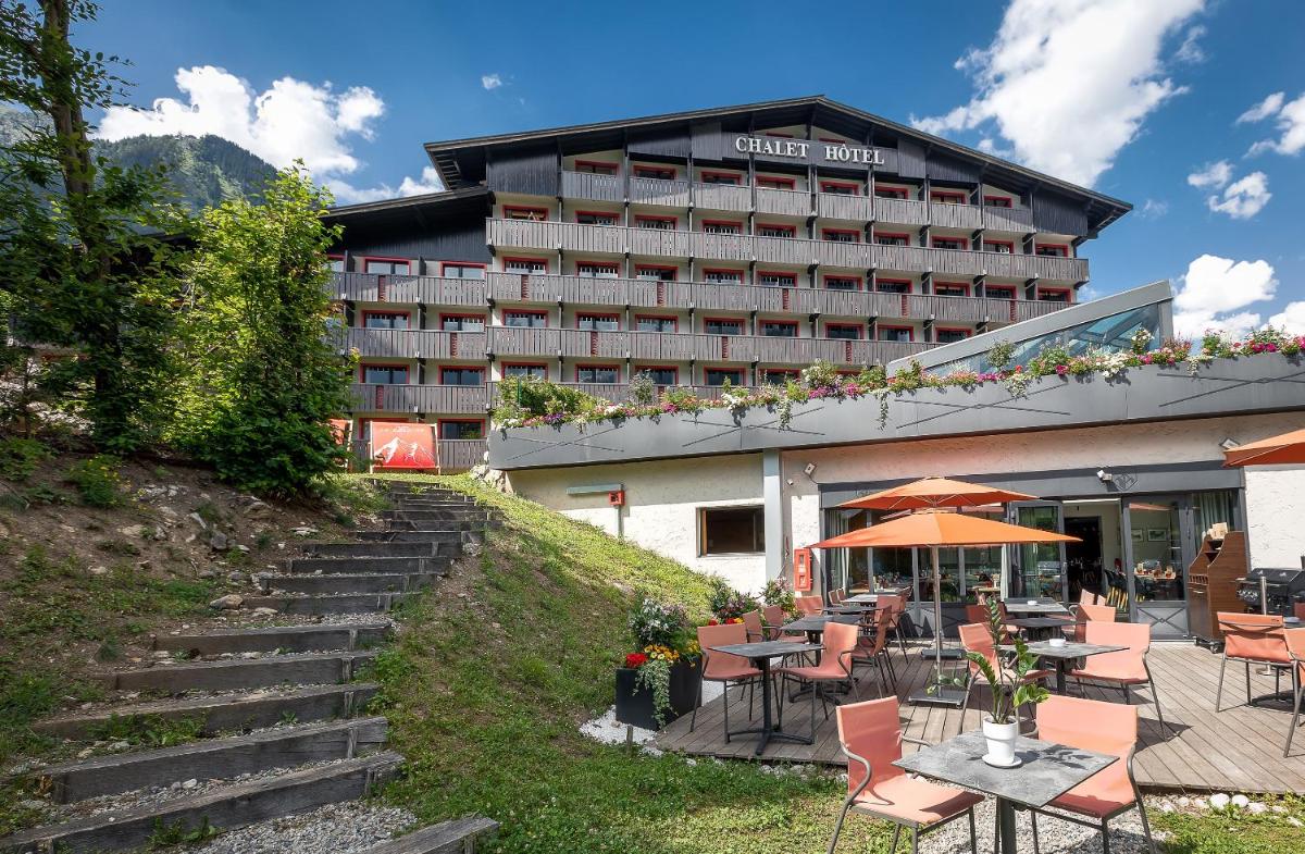 un hôtel avec des tables et des chaises devant dans l'établissement Chalet Hôtel Le Prieuré & Spa, à Chamonix-Mont-Blanc