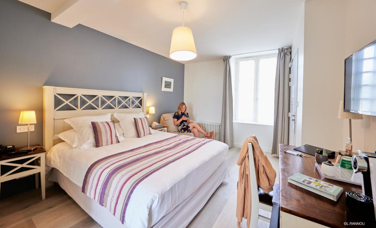 Un ou plusieurs lits dans un hébergement de l'établissement Logis Hotel, restaurant et spa Le Relais De Broceliande