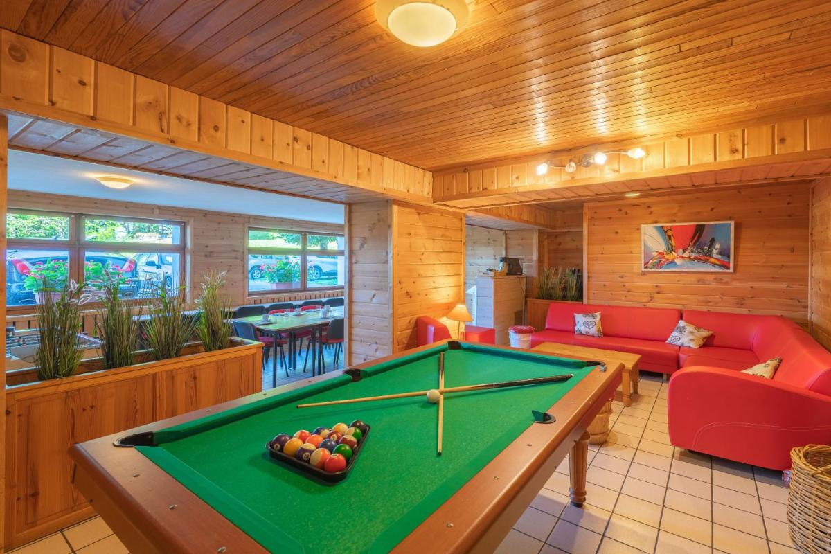 - un salon avec un billard dans une maison dans l'établissement Hotel Le Bois Joli, à Bernex